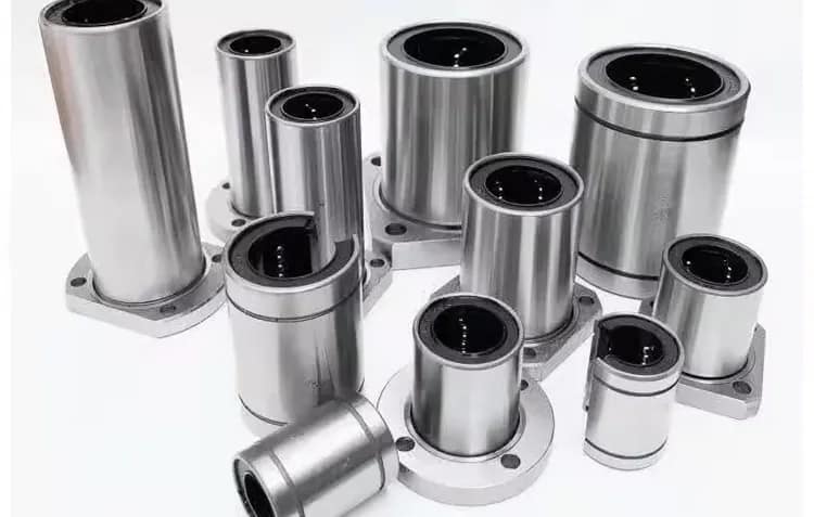 3D render showing a custom LMK series square flanged linear bearing (left) and an LMF series round flanged linear bearing (right), both with internal recirculating balls and synthetic retainers, designed for stable bolt-on linear motion.