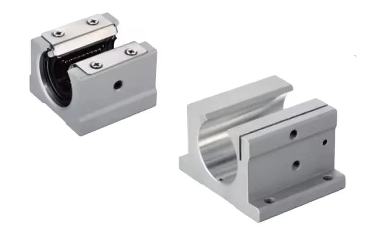 Top view of an assortment of linear motion slide block rails, showing a standard SCS series aluminum block (right) and a precision type with stainless steel dust covers (left), showcasing the recirculating ball bearing design for CNC and automation.